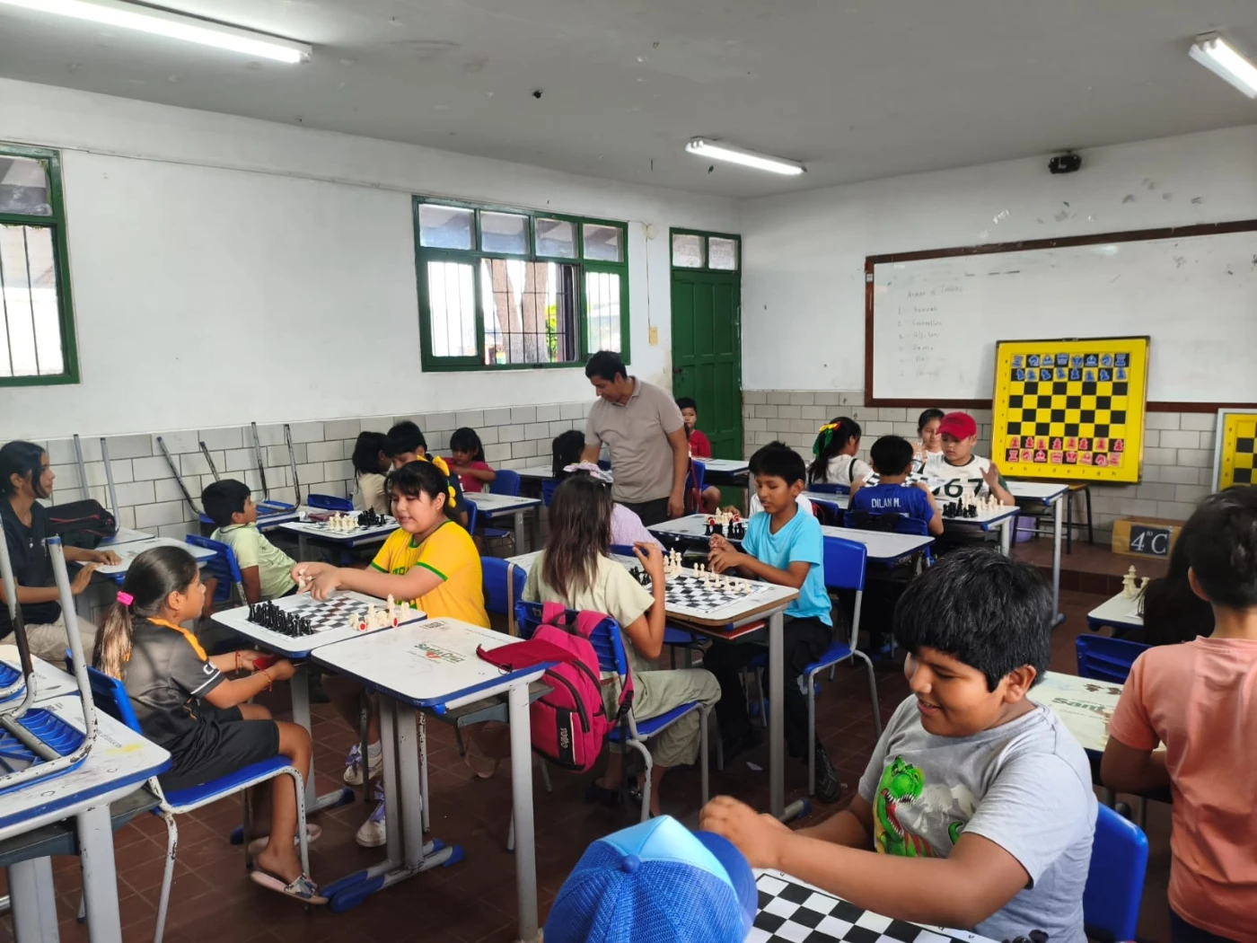 Clase de P.E.C.U.: los alumnos juegan en sus mesas con el tablero mural al frente